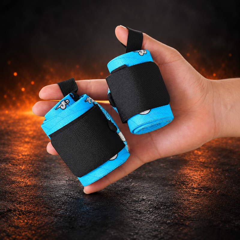 Hand holding a rolled pair of Kumo wrist wraps, sky-blue fabric with white clouds and black closure panels