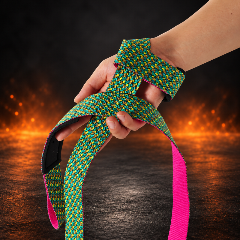 Bishamon lifting straps wrapped around a lifter's wrist, green, teal and gold cube print with a hot pink underside