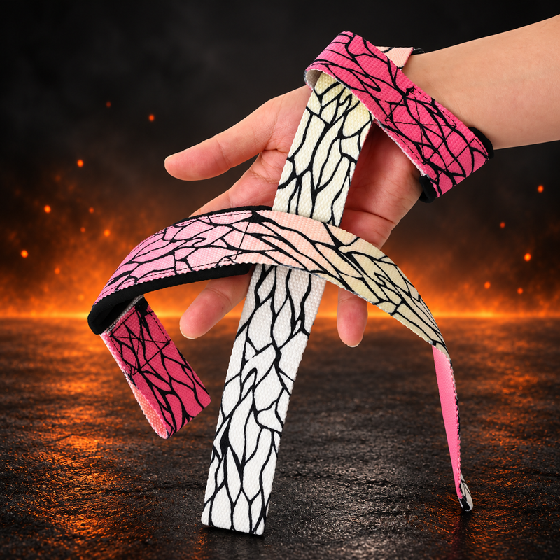 Both Chocho lifting straps looped over a hand, black wing veins on webbing that fades from deep pink to cream