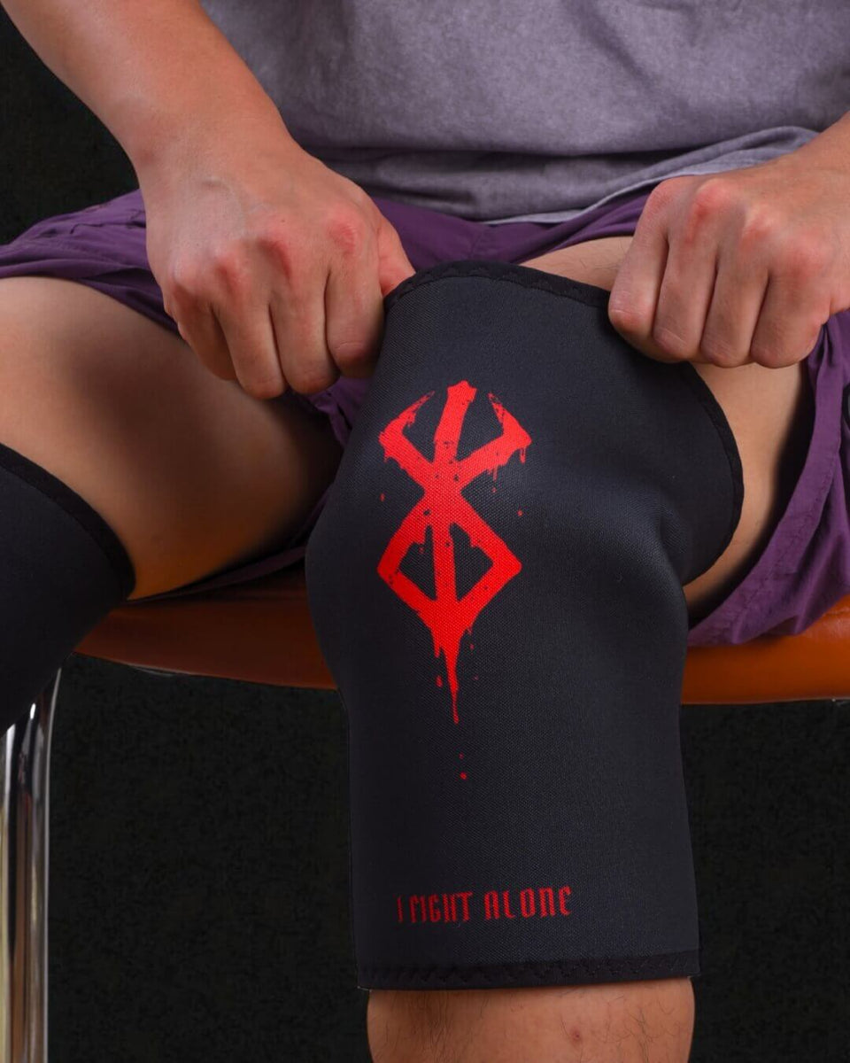 Person wearing Berserk knee sleeves, sitting on an orange stool.