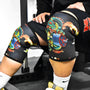 Person wearing black knee sleeves with colourful dragon artwork.