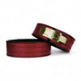 Two burgundy croc-grain Kobra lever belts on a white background, one showing its gold lever buckle.