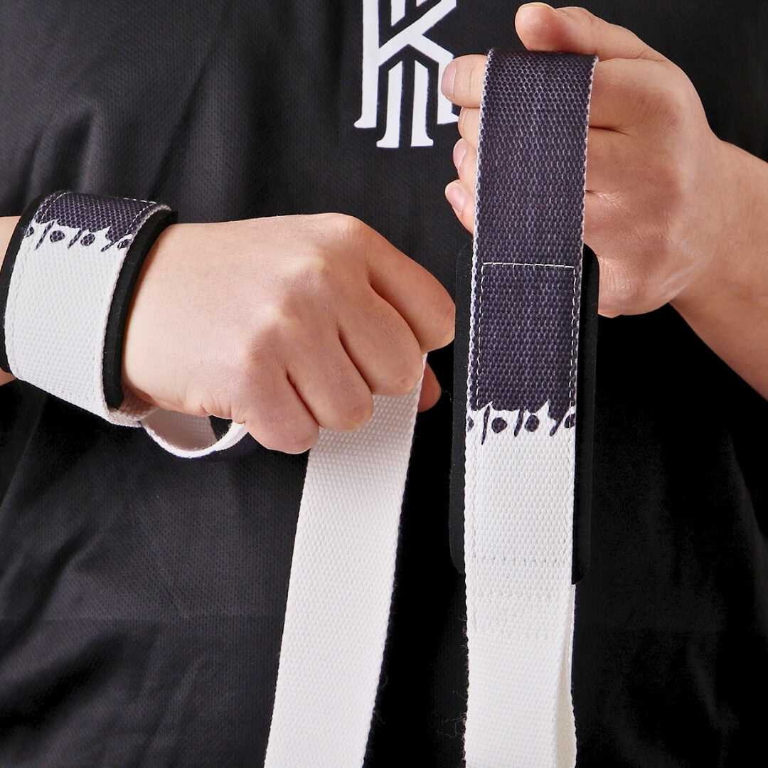 Lifter in a black tee putting on Sumi weightlifting straps, off-white webbing dipped in near-black ink at each loop