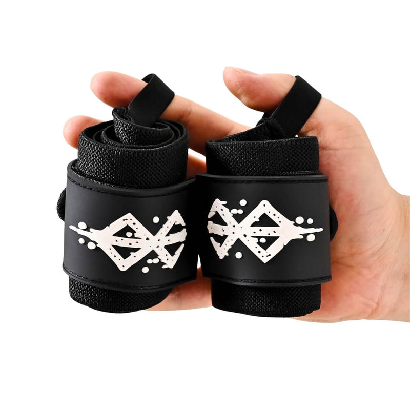 Rolled pair of Warrior wrist wraps held in one hand, all black with a distressed white sigil on each closure panel