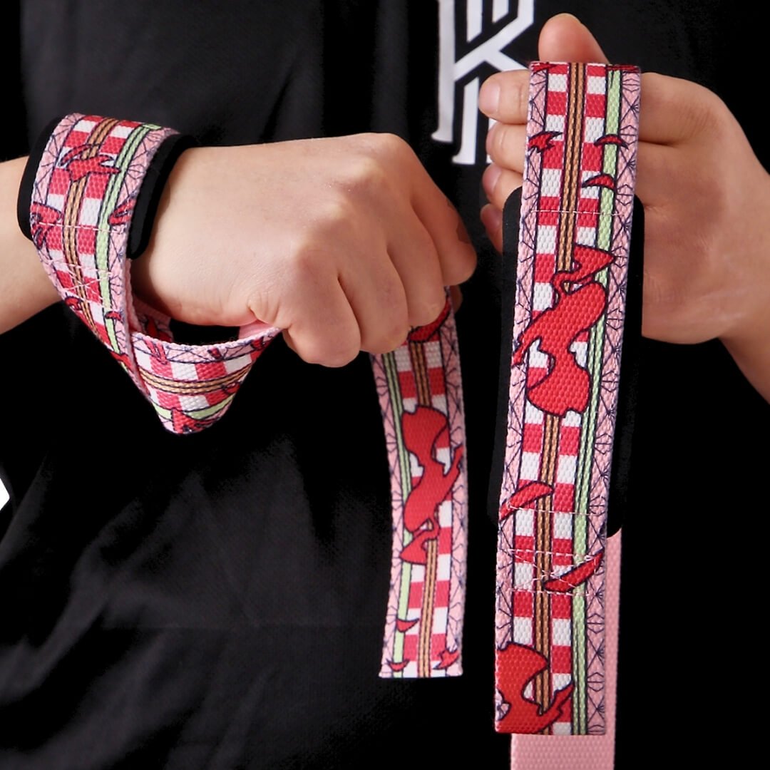 Lifter in a black tee wearing the Kurenai weightlifting straps, crimson shapes on red-white checks with pale green stripes