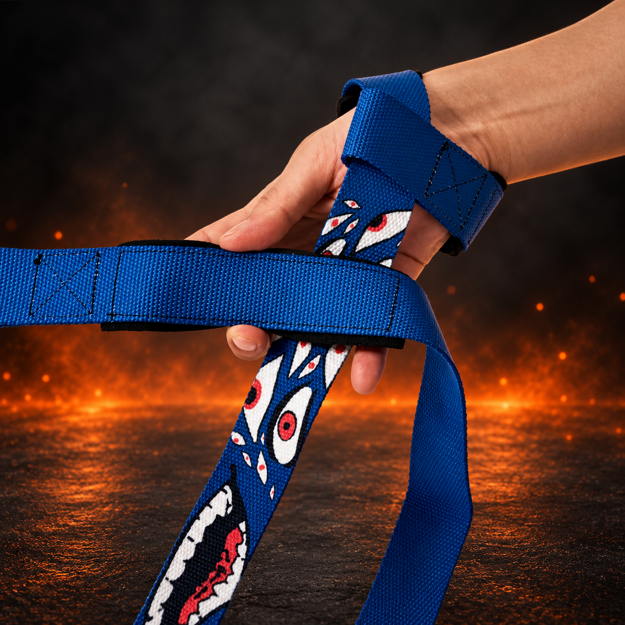 Hyakume lifting straps on a hand, one at the wrist and one across the palm, red-irised eyes and a toothy grin on deep blue
