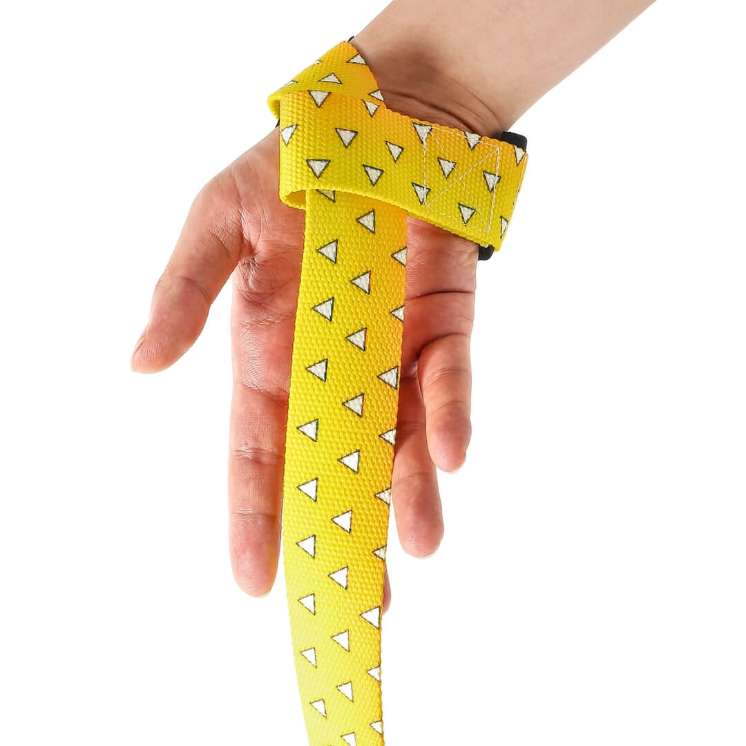Front view of the Uroko Edo weightlifting straps, a yellow strap with white triangle scales hanging from the wrist
