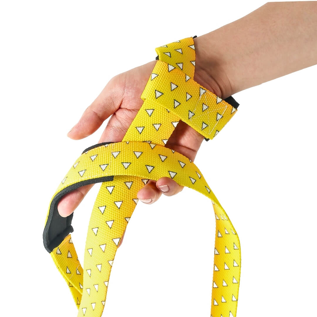 Edo deadlift straps in the yellow Uroko style, bright yellow webbing printed with white triangle scales, looped in the hand