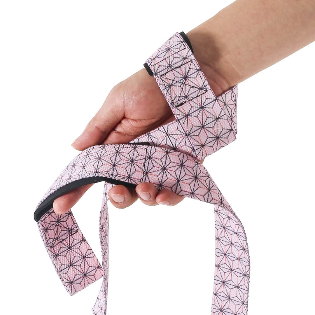 Edo deadlift straps in the pink Asanoha style, pale pink webbing with a dark hemp leaf star pattern looped over the hand