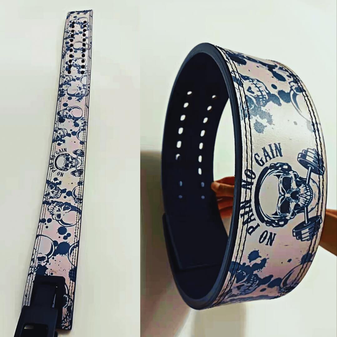 Custom powerlifting lever belt from a past order with navy skulls and splatter on white, shown flat and curled.