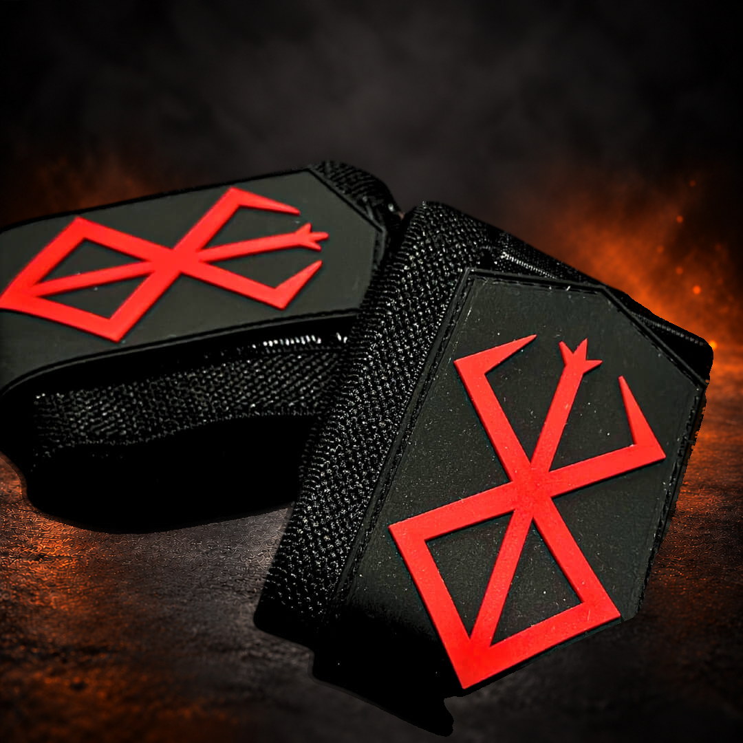 Powerlifting wrist wraps with raised red sigils on two rolled black tabs, extreme close-up.