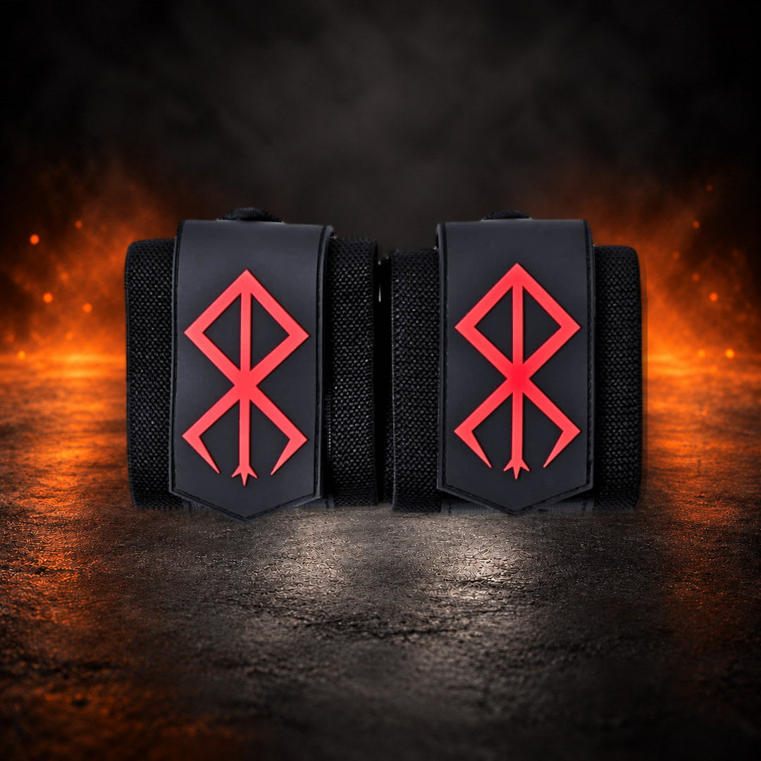 Powerlifting wrist wraps, black pair side by side with red sigils on the tabs, front view.
