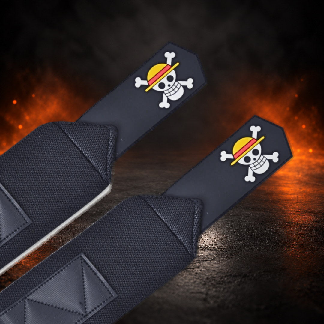 Powerlifting wrist wraps with a skull in a red-banded yellow hat on each black tab, close-up.