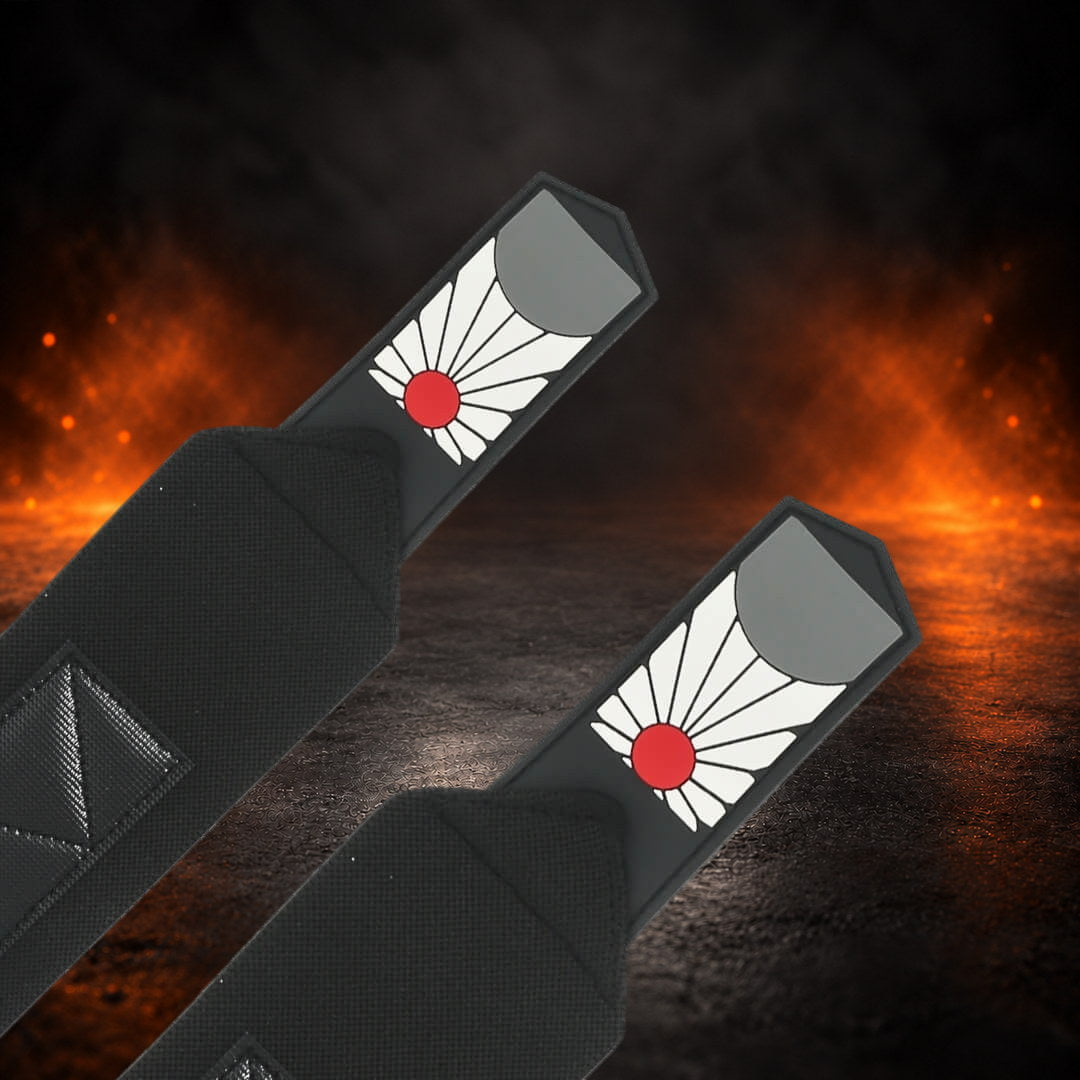 Powerlifting wrist wraps with a red sun, white rays and gray half-disc on each tab, close-up.