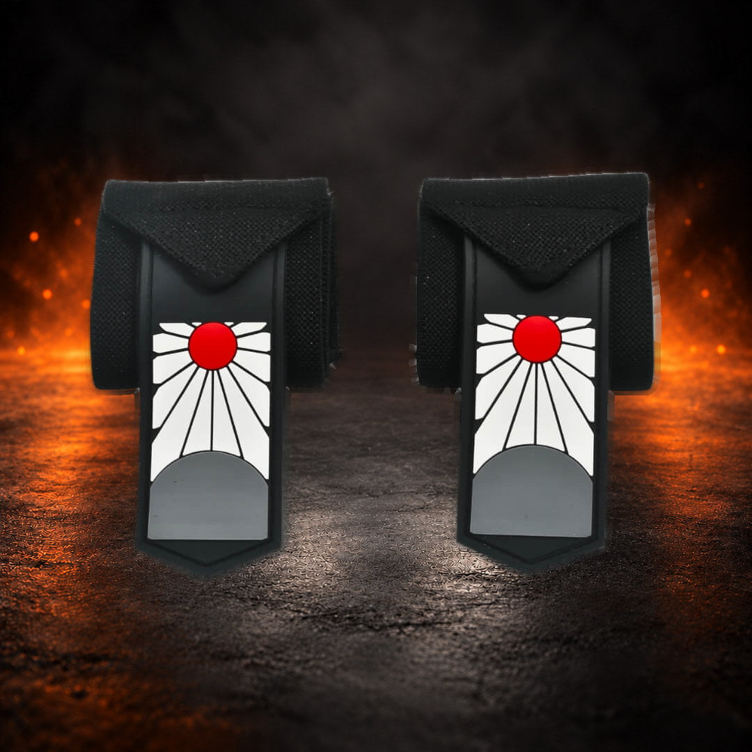 Powerlifting wrist wraps, folded black pair with red sun tabs hanging down, front view.