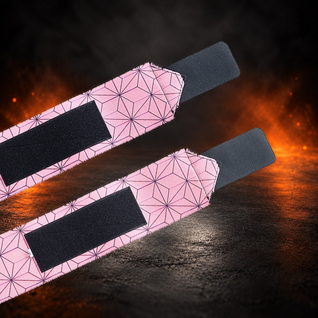 Powerlifting wrist wraps in pink hemp-leaf print with black hook-and-loop closures, tail ends close-up.