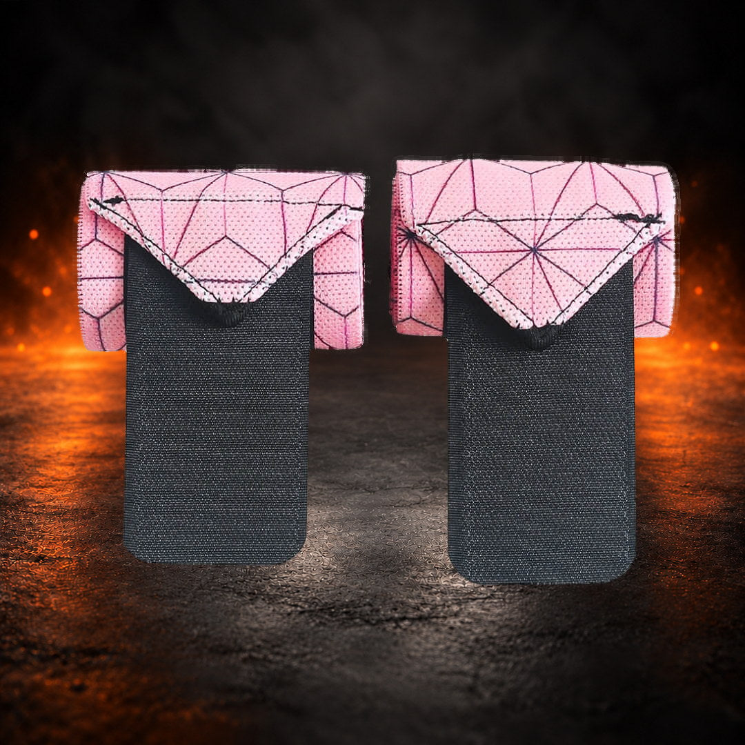 Powerlifting wrist wraps in pink hemp-leaf print, folded pair with long black closure tabs hanging down.