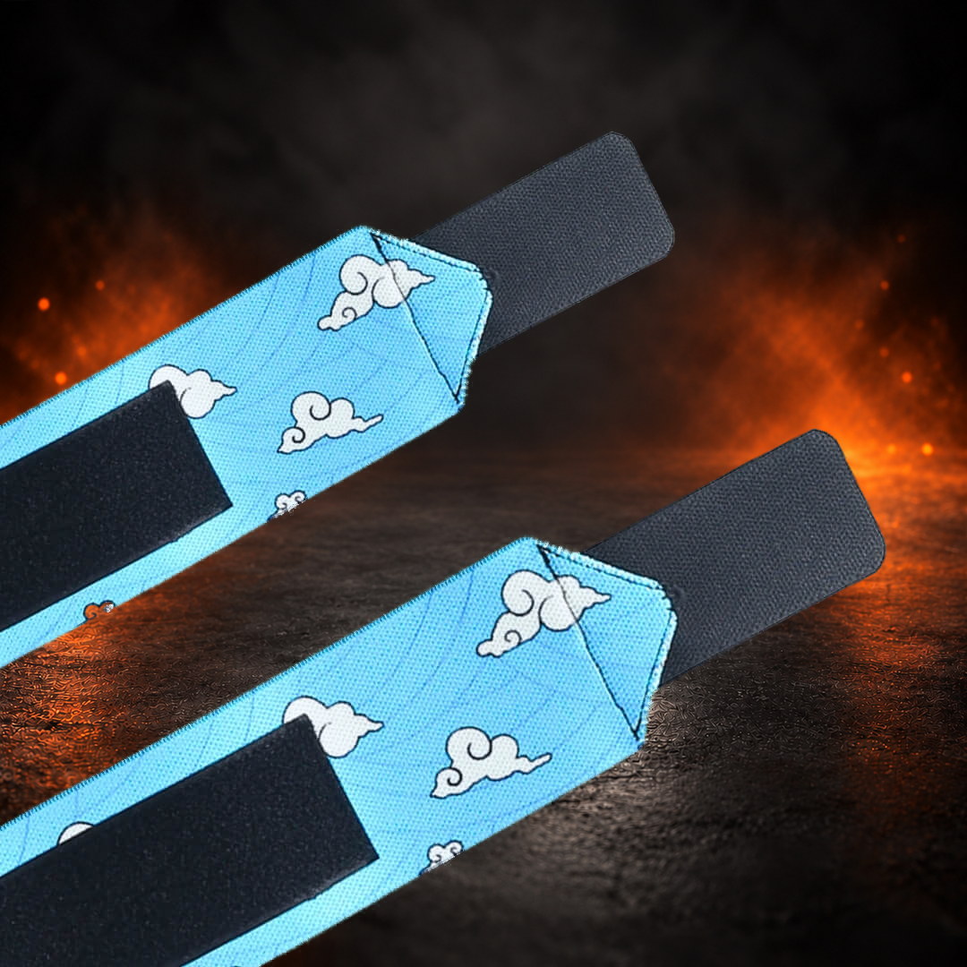 Powerlifting wrist wraps in sky blue with white curling clouds and black tabs, tail ends close-up.