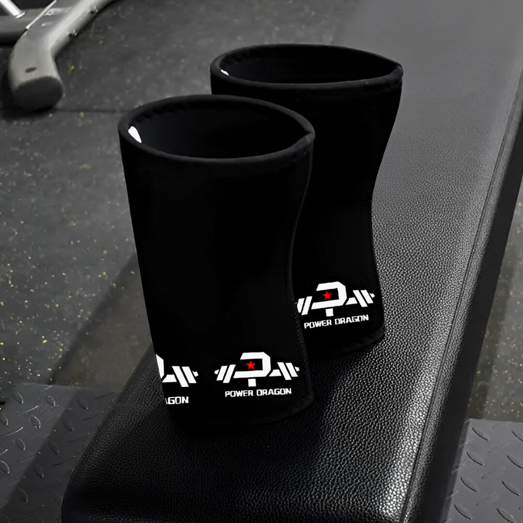 7mm stiff knee sleeves in black with red-star barbell logos, pair standing upright on a gym bench.