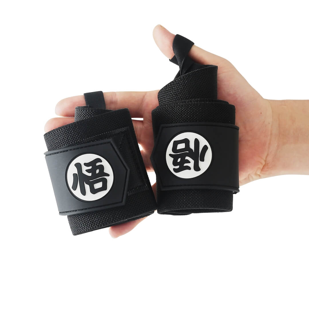 Powerlifting wrist wraps in all black with kanji in white circles, rolled pair in hand.