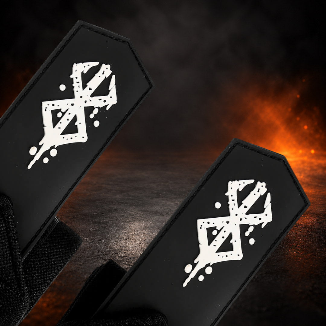Powerlifting wrist wraps with a spattered white sigil on each pointed black tab, close-up.