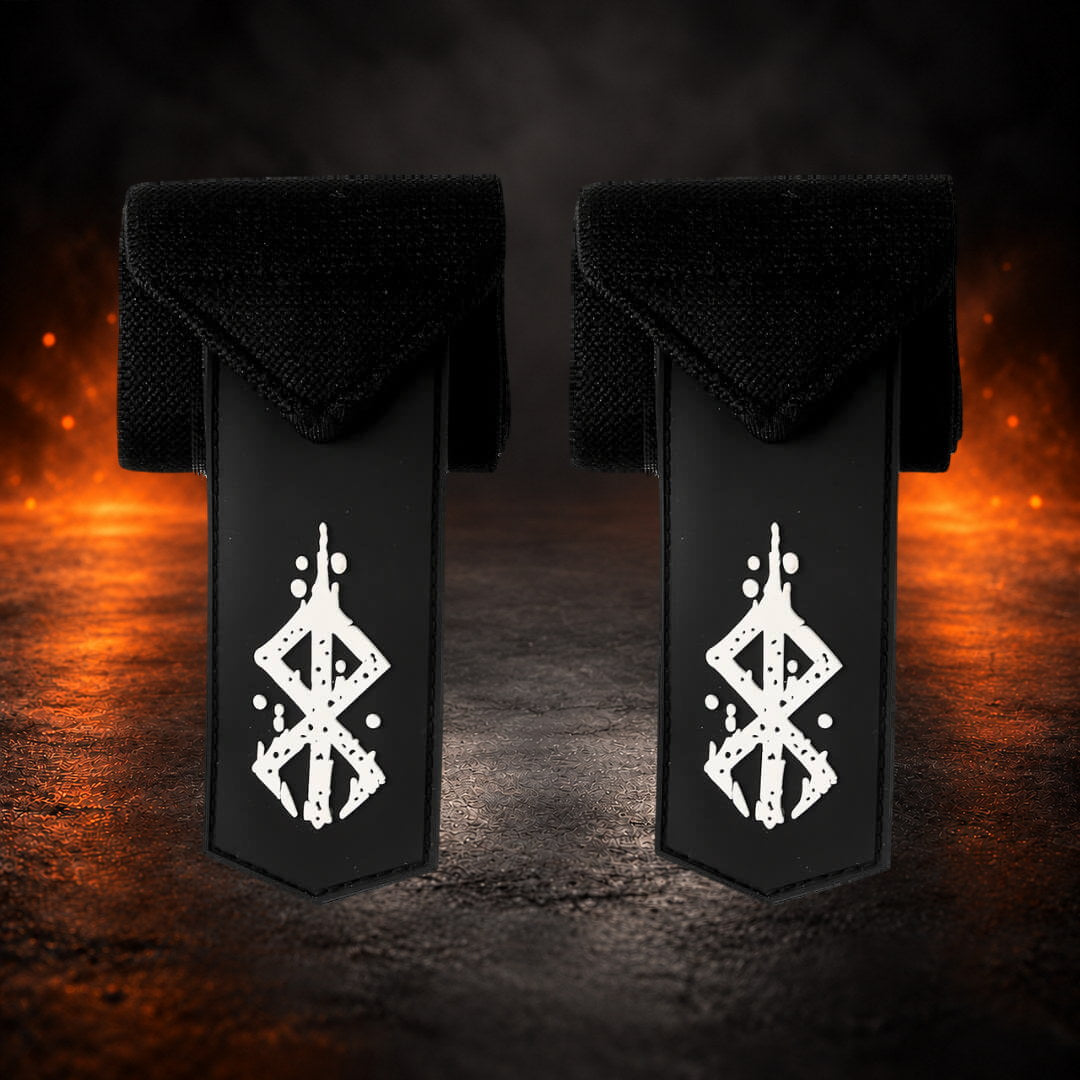 Powerlifting wrist wraps in black with white sigil tabs hanging below the rolled pair, front view.