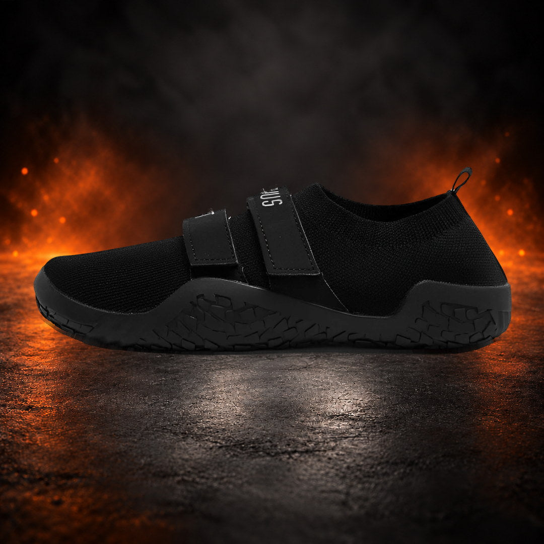 Deadlift slippers in black with matching straps and sole, side view.
