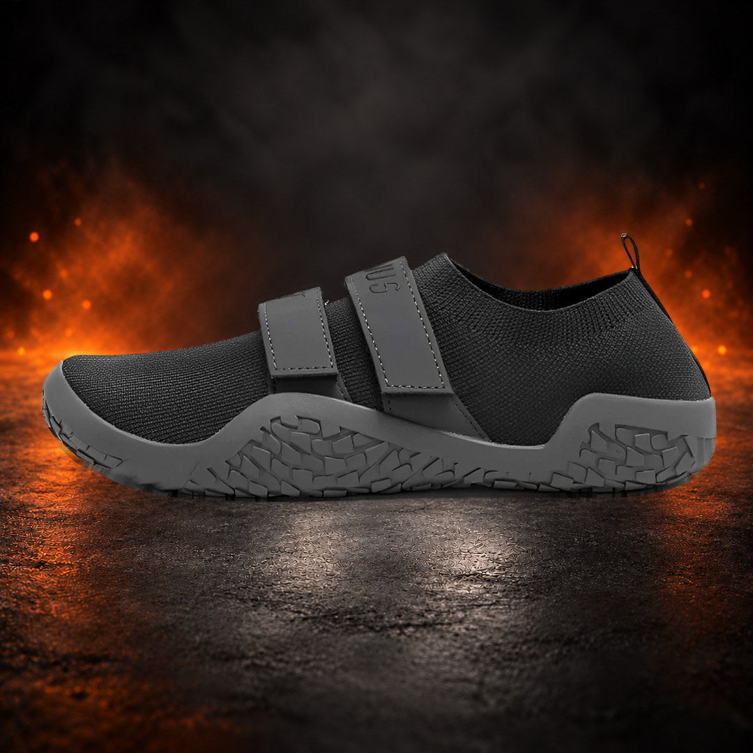 Deadlift slippers in black with grey straps and a grey sole, side view.