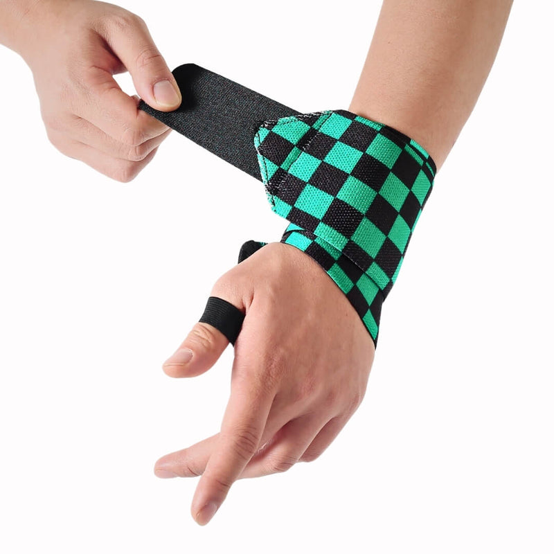 Ichimatsu wrist wraps being fastened on a lifter's wrist, green and black checkerboard with a black thumb loop