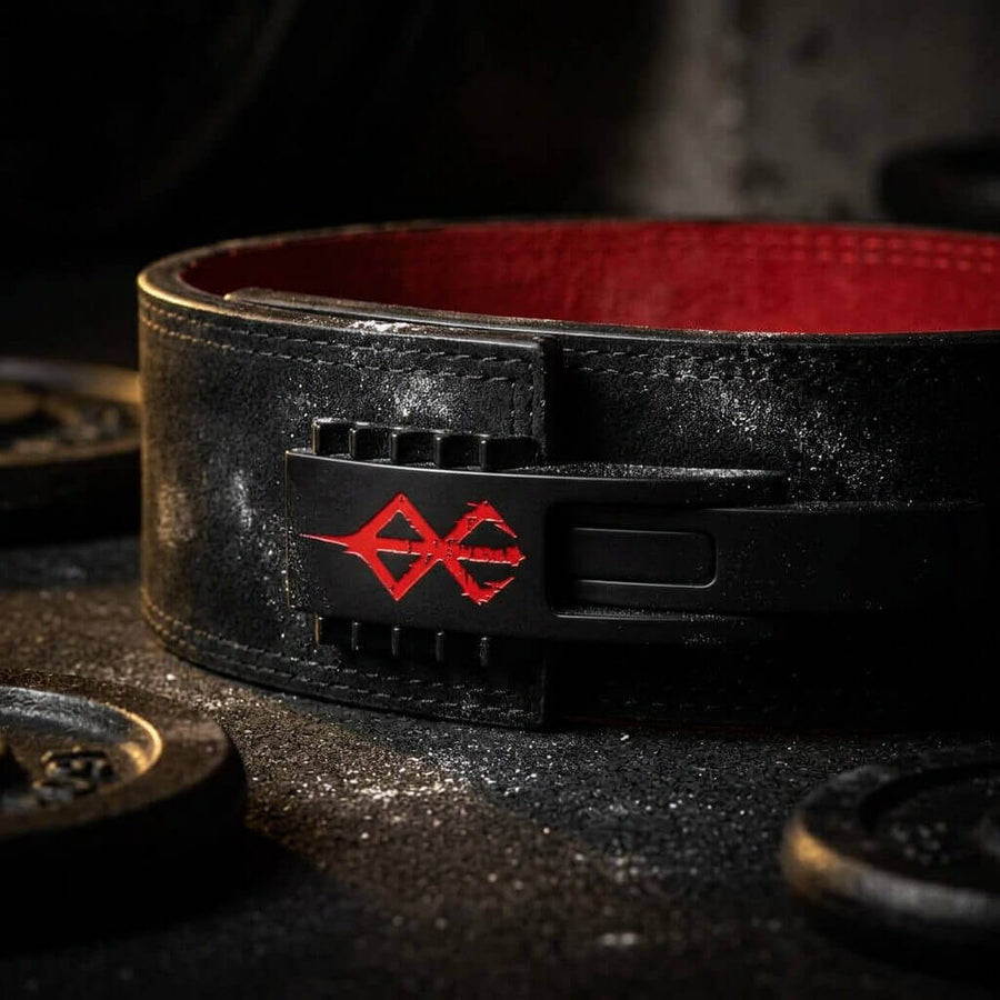Black leather powerlifting lever belt with a red emblem on a dark background